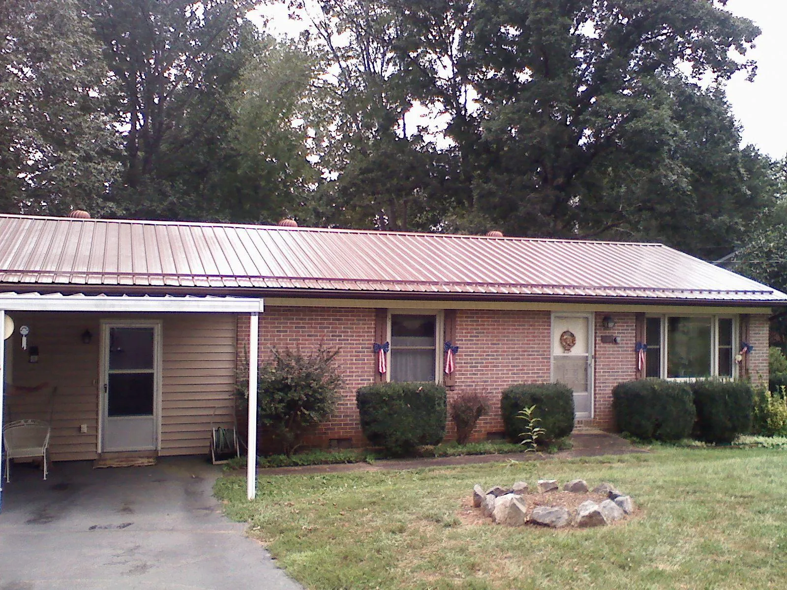 Bronze metal roof and carport on a brick ranch home — Roof Repair work by our crew in Anniston