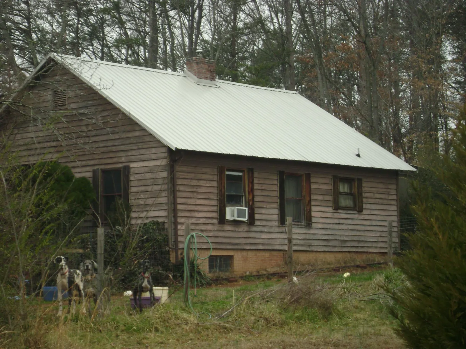 White metal roof on an old wood sided farmhouse, from a Metal Roof Installation job in Anniston